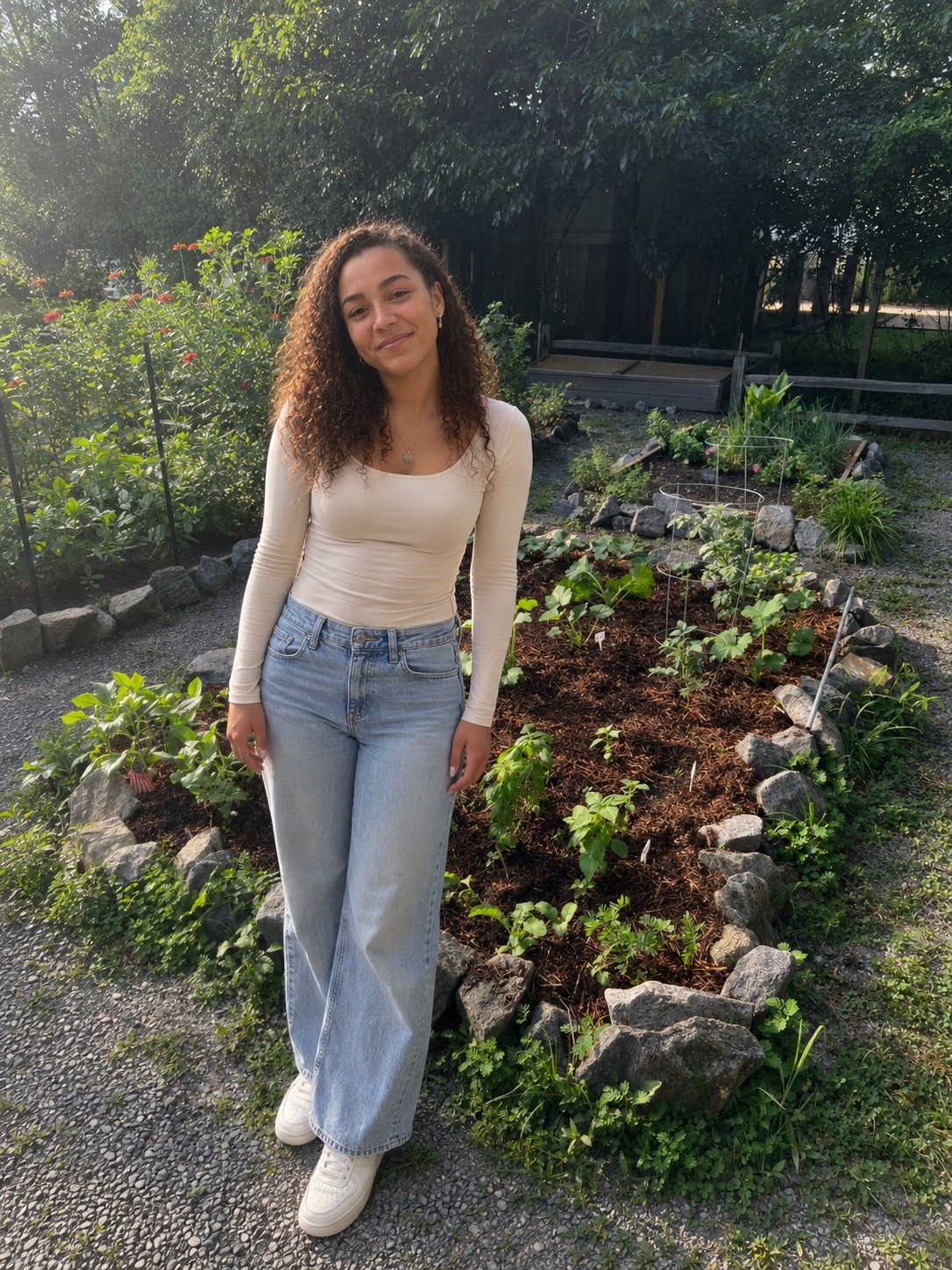 Research participant standing beside planted garden beds