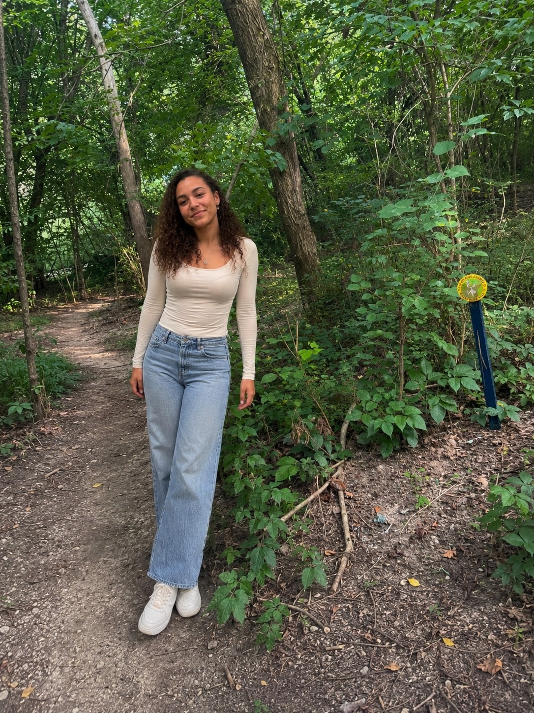 Research participant standing along a wooded trail